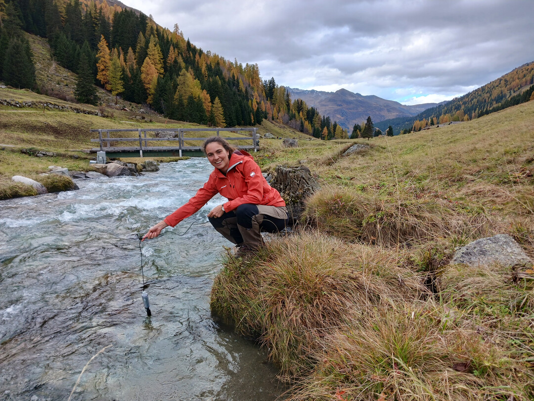 SLF-Hydrologin Amber van Hamel hlt einen Sensor in den Dischmabach bei Davos.