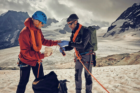 Bergsteiger entnehmen Proben aus einem Gletscher.