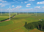 Abb. 2: Luftbild der Graureiherkolonie 2020 (Baumbestand rechts vorne) mit dem Bestandswindpark im Hintergrund und den neu errichteten Windenergieanlagen (rote Kennzeichnung)