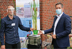 Dr. Colja Beyer überreicht Minister Olaf Lies zum Projektstart symbolisch eine Rohrkolbenpflanze.