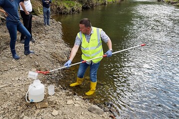 Entnahme einer Wasserprobe an der Ahr